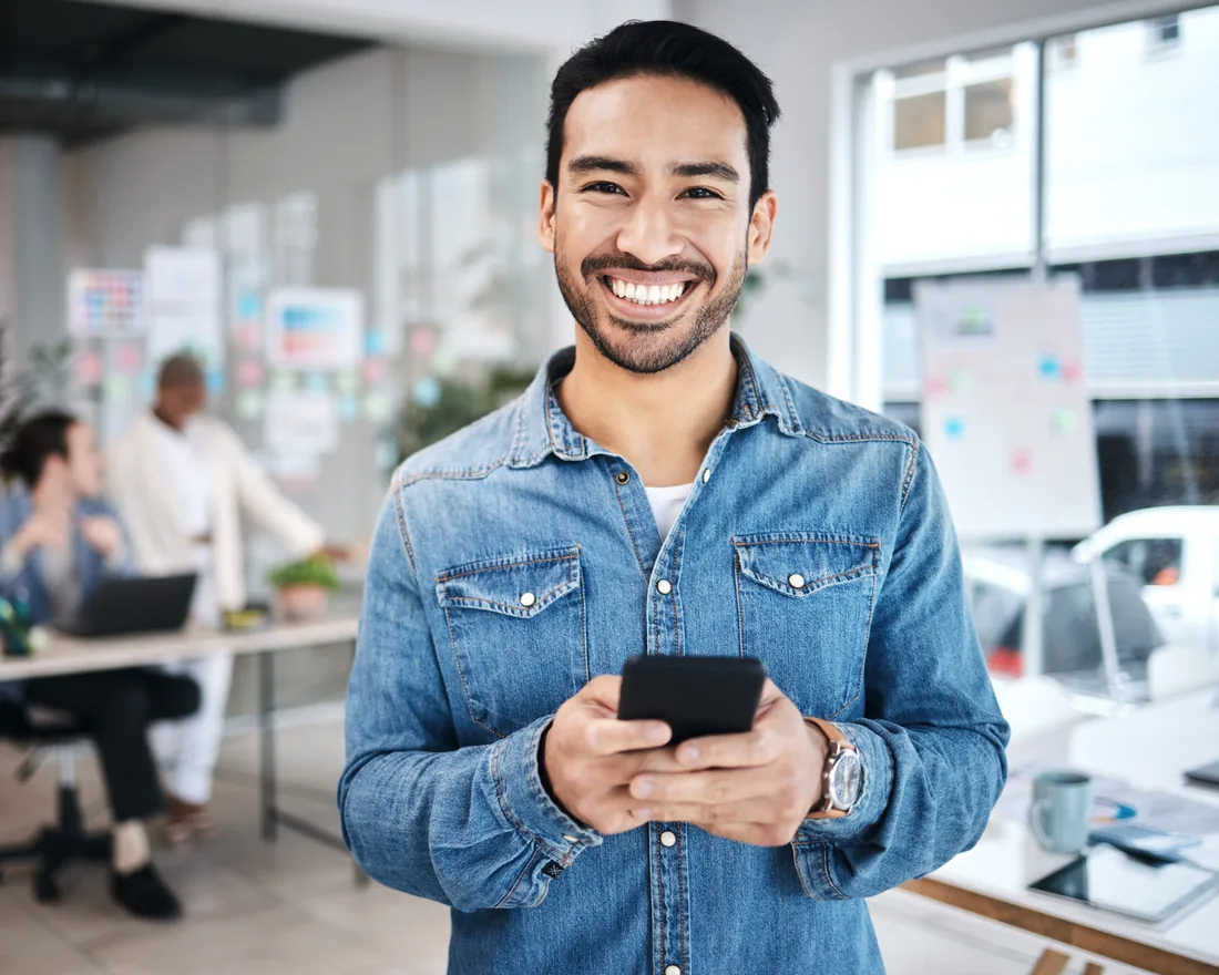 Hombre sonriente con su celular en las manos